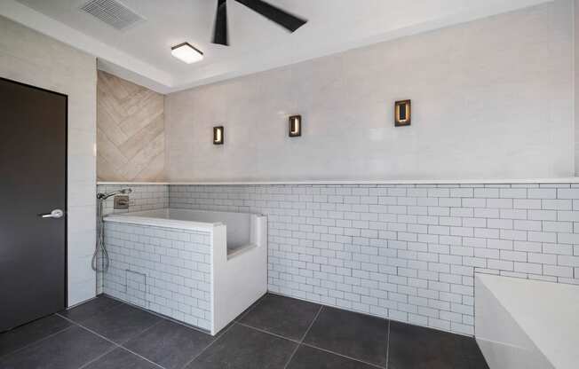a bathroom with white tiles and a tub and a sink
