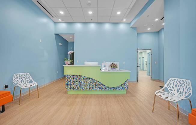 A room with a blue wall and a green table with a mosaic design.
