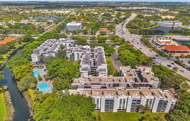 A large building complex is surrounded by a river and greenery.