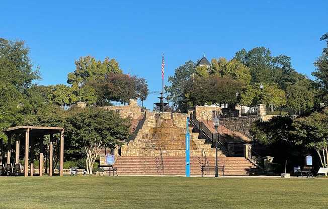 A park with a gazebo, steps, and a flag.