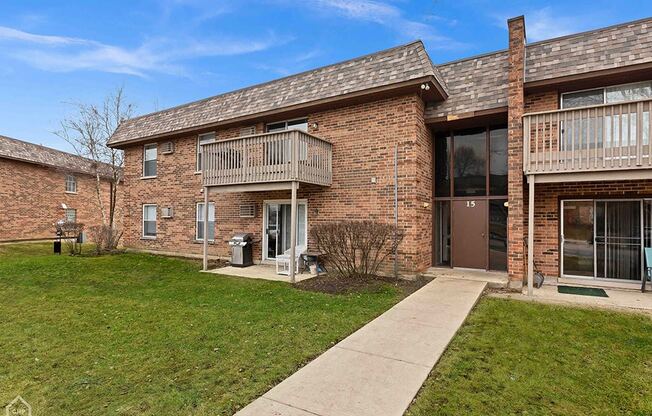 a brick apartment building with a sidewalk in front of it