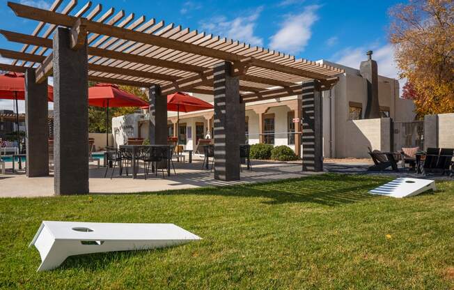 a patio with a pergola and tables with umbrellas