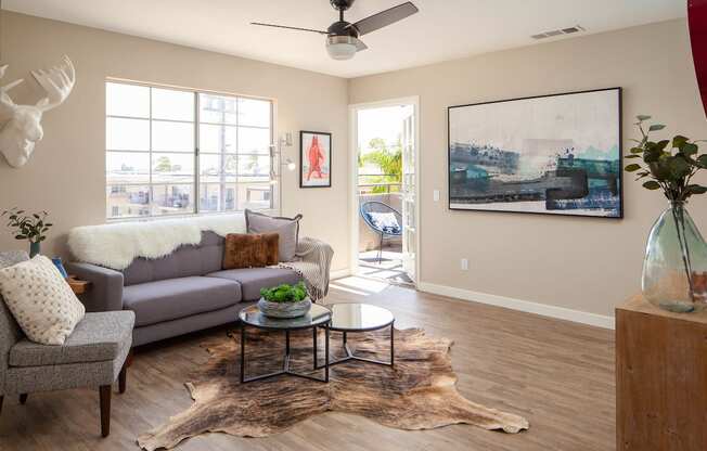 Living room with large windows and door to balcony at Driftwood, San Diego