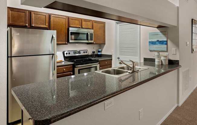 a kitchen with a granite counter top and stainless steel appliances