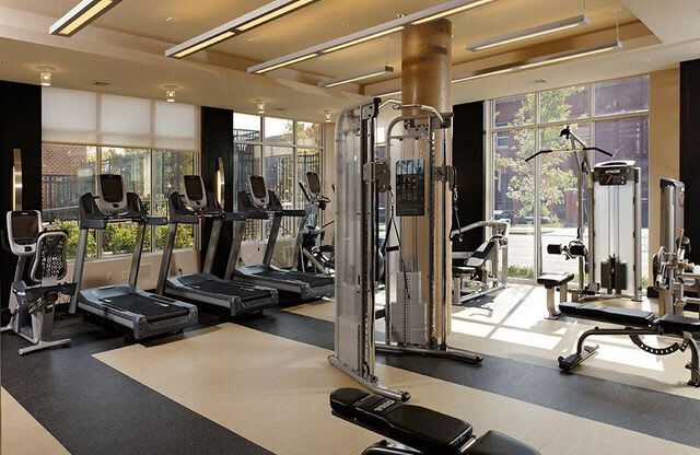 Fitness center with large windows, treadmills and a workout bench