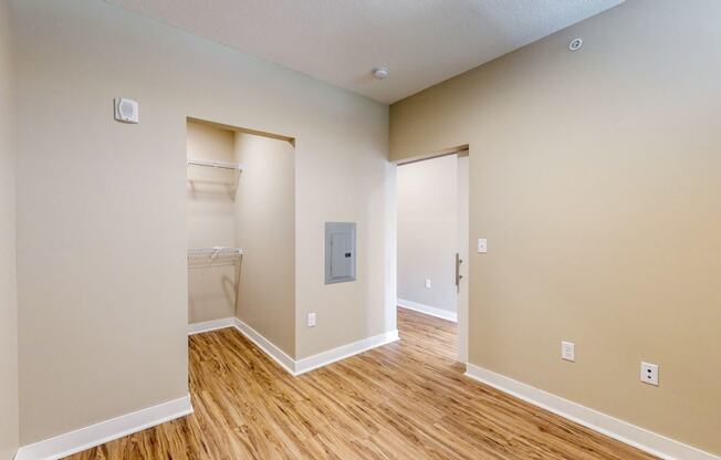 a renovated living room with wood flooring and a door to a bathroom