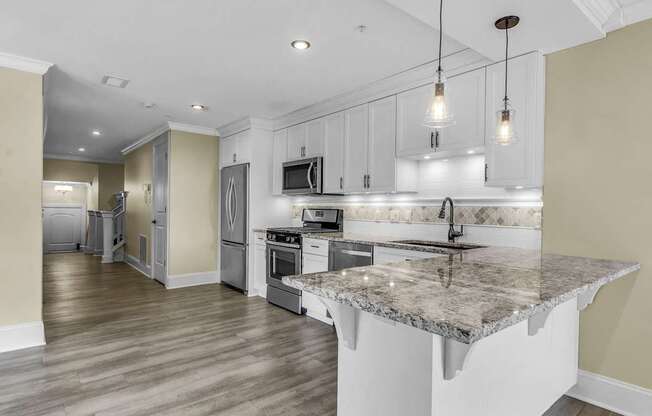 A kitchen with a granite countertop and stainless steel appliances. at The Knights @ 506 Delaware Apartments, Buffalo, NY