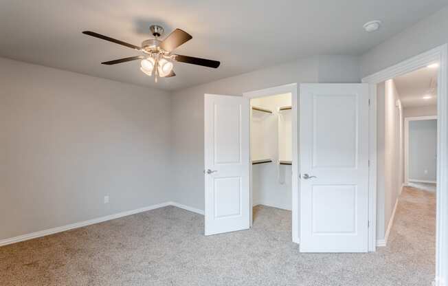 a bedroom with a ceiling fan and closet