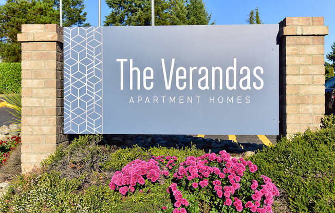A sign for The Verandas Apartment Homes is displayed in front of a building.