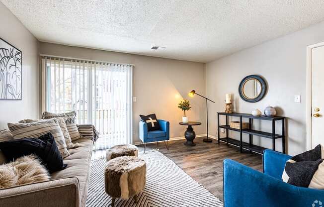a living room with a couch and chairs and a sliding glass door