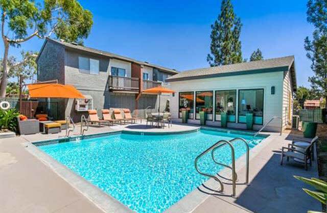 Pool With Lounge Chairs, Umbrellas, Trees, And Clubhouse at Encore Apartments, California