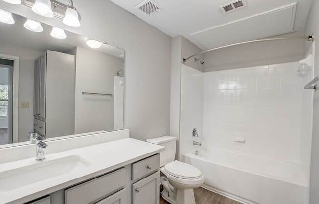 A white bathroom with a toilet, sink, and bathtub.