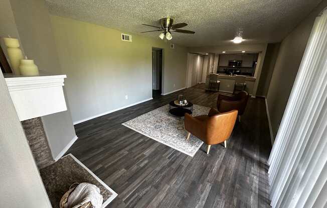 A living room with a fireplace and a ceiling fan.