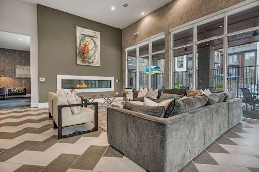 A living room with a grey sofa and a checkered floor.