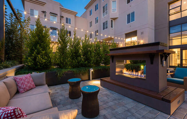 Courtyard seating area and fireplace at night at Aventine, Hercules, CA, 94547