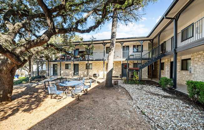 a courtyard with a table and chairs in front of a building