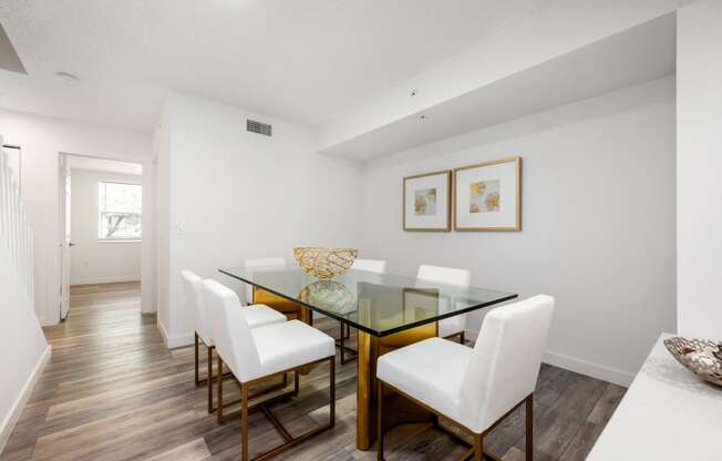 a dining room with a glass table and white chairs