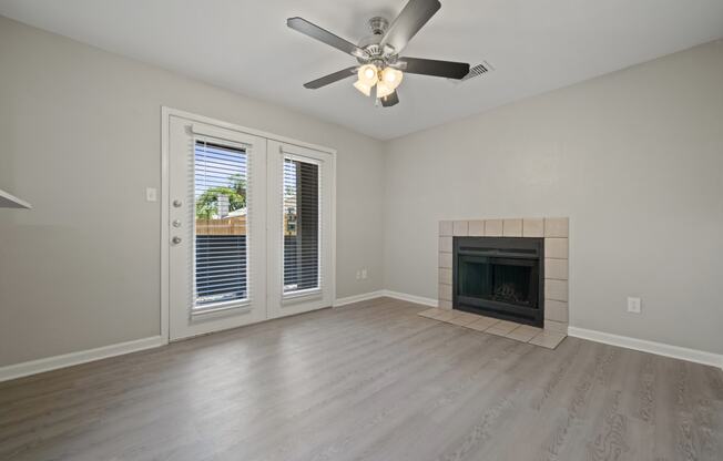 a living room with a fireplace and a ceiling fan