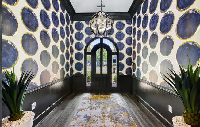 a hallway with blue and yellow wallpaper and a chandelier