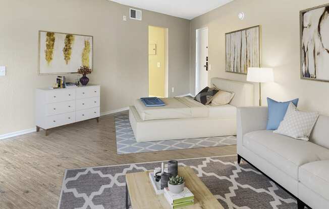 a bedroom with a bed couch and dresser in a 555 waverly unit