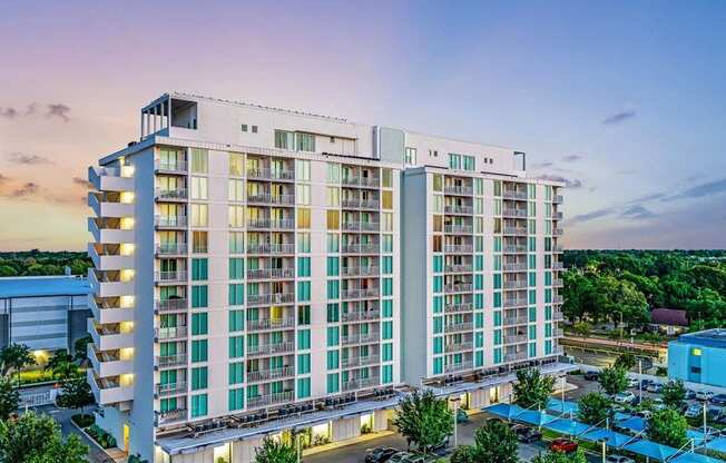 A large hotel building with a parking lot in front.