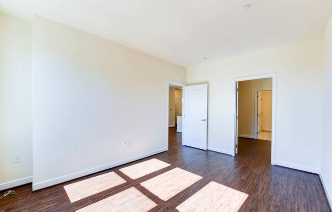 vacant bedroom with hardwood flooring, closet and view of bathroom at archer park apartments in washington dc
