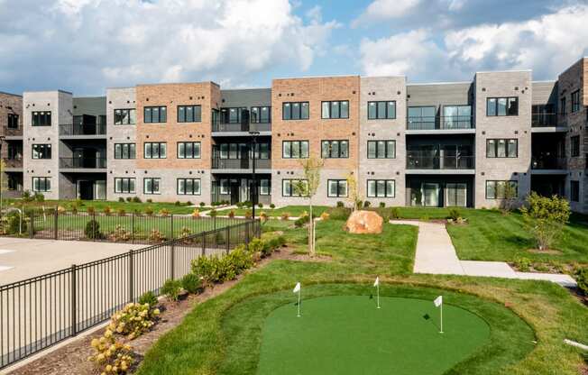 an exterior view of an apartment building with a golf course