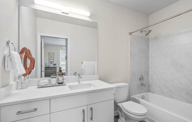 a bathroom with a white sink and toilet next to a white bathtub with a shower curtain