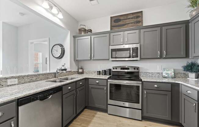 A kitchen with dark cabinets and stainless steel appliances.