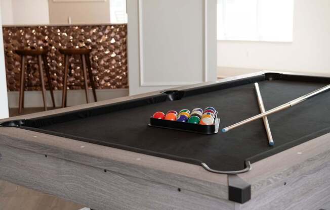 A pool table with a set of cues and balls on it.