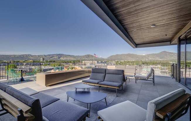 A patio with a table and chairs overlooking a mountain range.