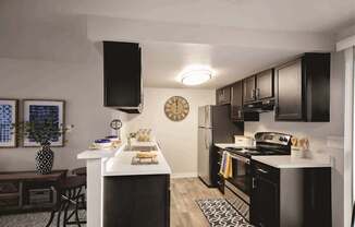 A black and white kitchen with a clock on the wall.