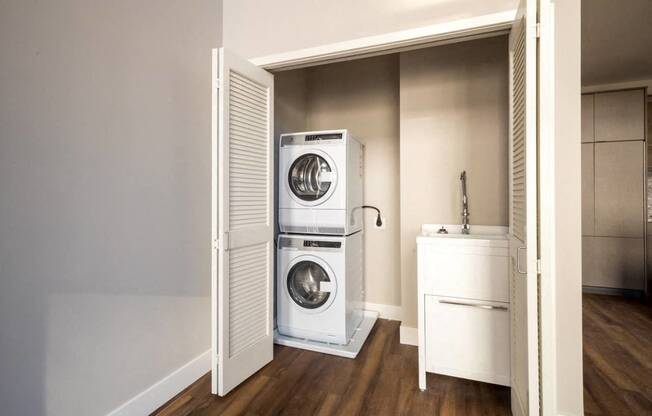 a small laundry room with a washing machine and a sink at Ann Arbor City Club, Ann Arbor, MI