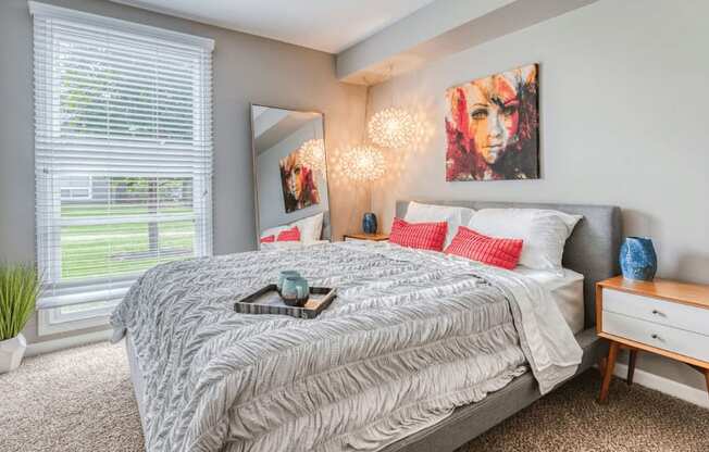 a bedroom with a large bed and a large window at The View Apartments St Charles, Illinois