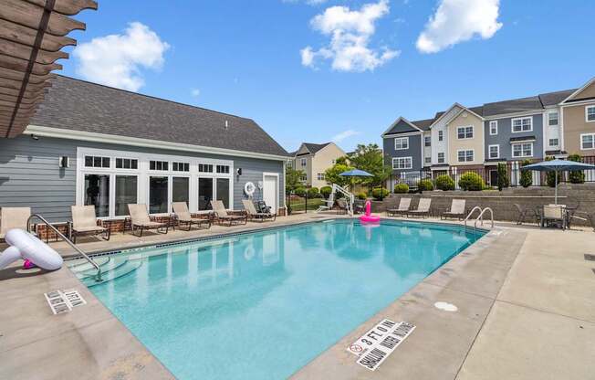 A swimming pool with a slide and a building in the background.