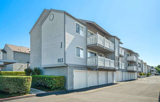 a street view of an apartment building with garages and balconies