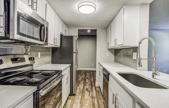 A kitchen with white cabinets and a black stove top oven.