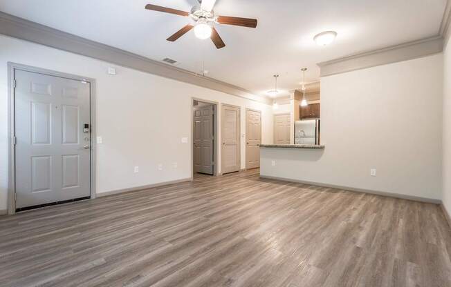 A room with a ceiling fan and wooden flooring.