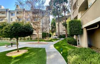 a walkway between two apartment buildings with a picnic table in the middle of the walkway