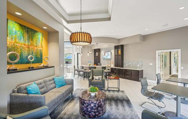 A modern living room with a grey sofa and a large abstract painting on the wall.