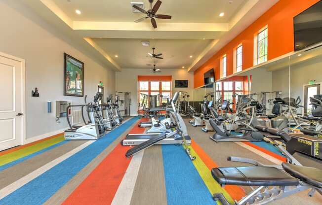 a gym with treadmills and other exercise equipment in a large room with windows at Hacienda Club, Jacksonville