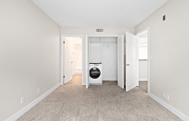 a bedroom with a washer and dryer