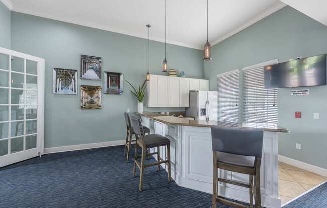a kitchen with a bar and chairs and a refrigerator