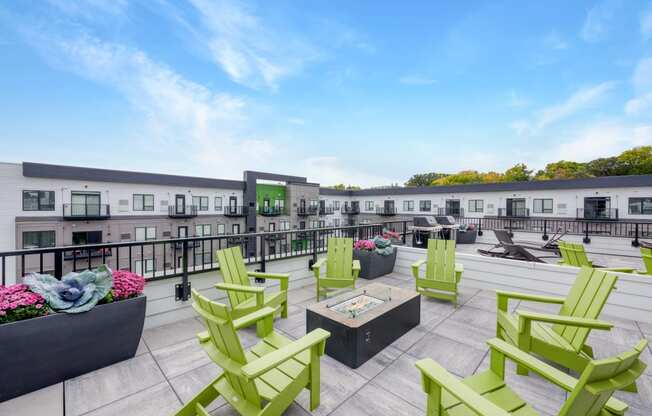 a rooftop patio with green chairs and patio furniture