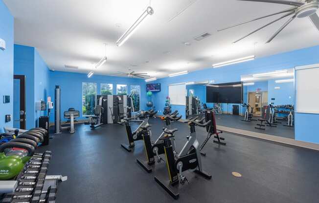 a fitness center with cardio equipment and weights in a gym