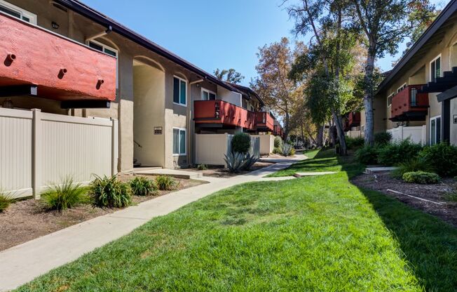 Apartments in Westlake Village for Rent - Meadows West Village - Exterior Building with Walkway and Lush Greenery