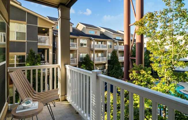 a balcony with a chair and a view of an apartment building