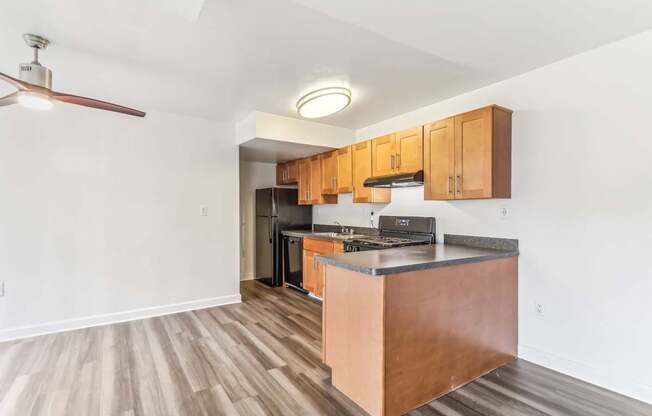 a kitchen with wooden cabinets and a counter top and a stove and refrigerator