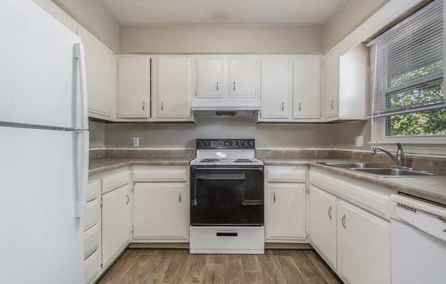 Omaha, NE Maple Ridge Apartments. A kitchen with white cabinets and white appliances