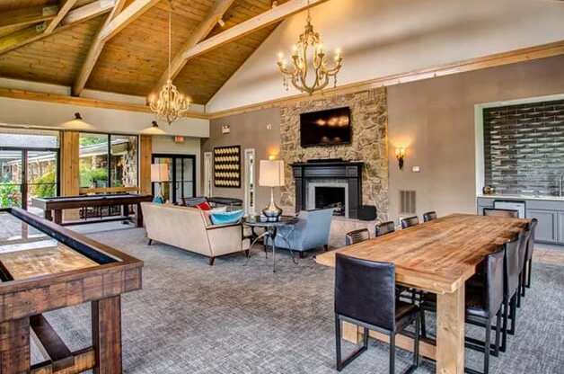 a large living room with a large wooden table and a fireplace